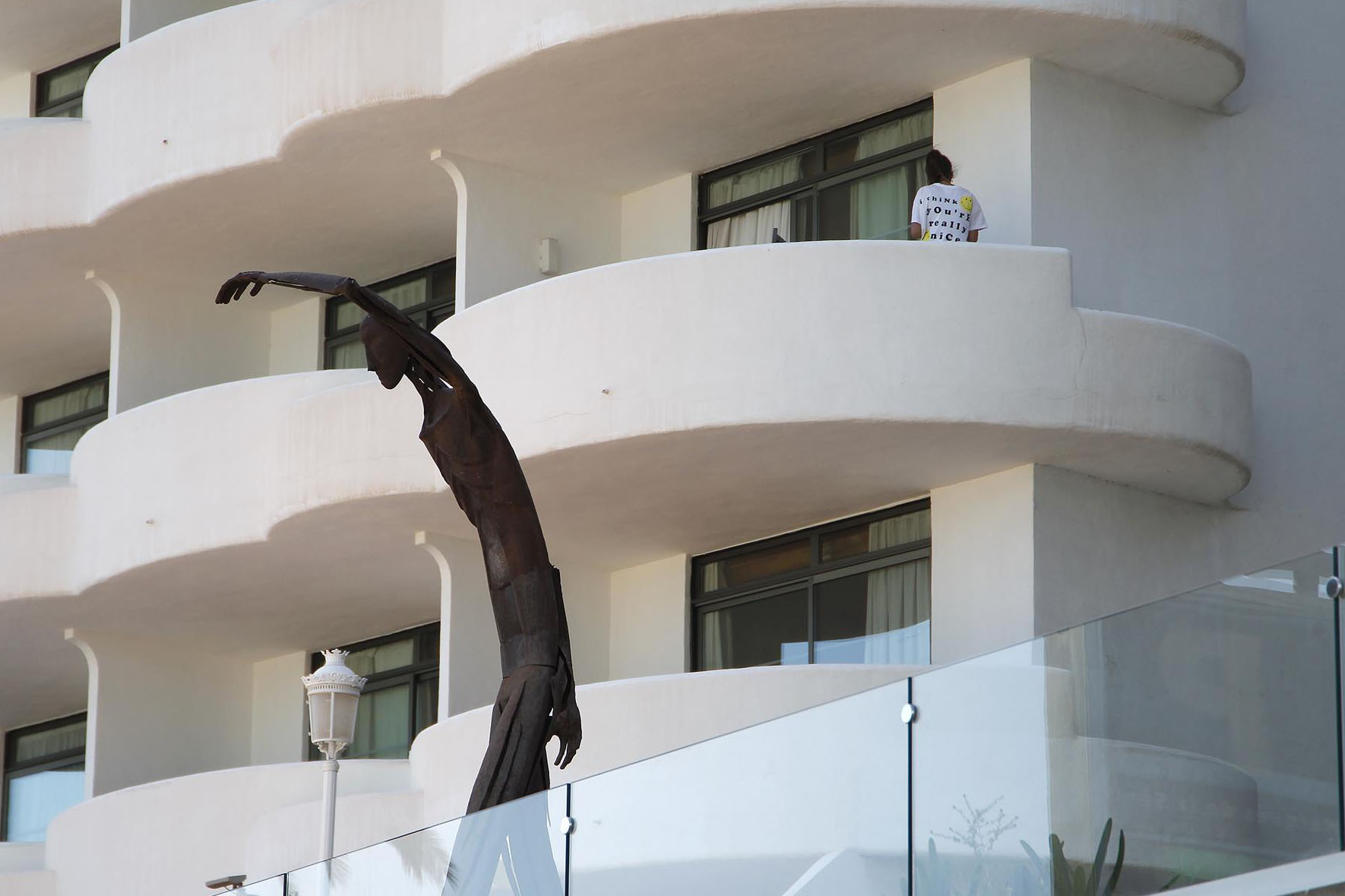 Un joven en un balcón del hotel Palma Bellver, donde estaban confinados 249 jóvenes. EP