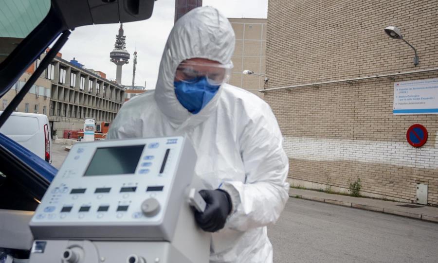 Un técnico protegido con un traje, guantes y mascarilla en el Hospital Gregorio Marañón, saca un respirador del maletero de su coche en Madrid. Foto de Ricardo Rubio - EP