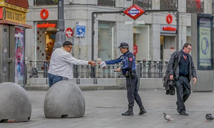 Un policía municipal de Madrid pone una multa a un viandante por no respetar la cuarentena en Madrid. Foto de Ricardo Rubio - Europa Press