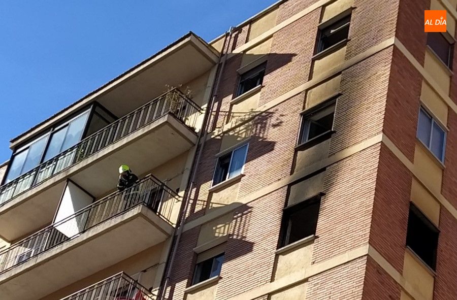 Uno de los Bomberos inspeccionando el piso en el que tuvo lugar el incendio, desde un balcón