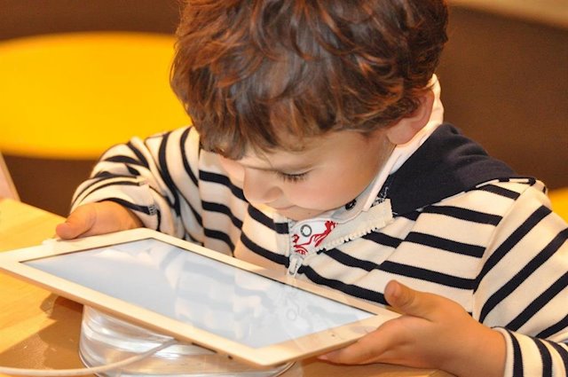 Un niño mira una tablet