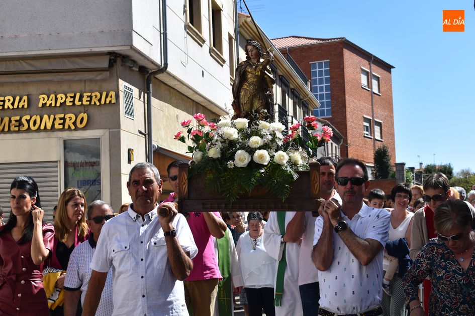 Los vecinos procesionan la imagen de San Miguel por las calles del barrio