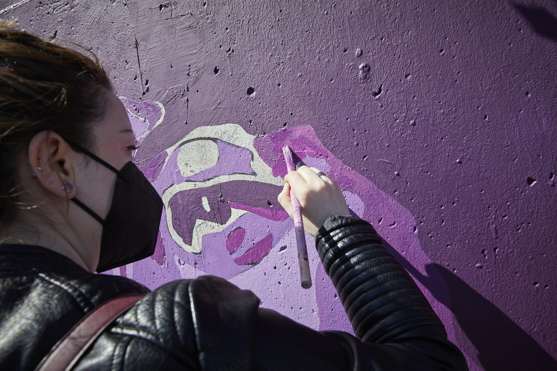 Una joven pinta un mural / EP