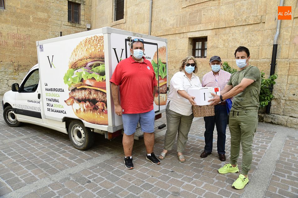Trabajadores de la empresa hacen entrega de las hamburguesas a responsables de San Vicente de Paul/ Foto: Adrián M. Pastor