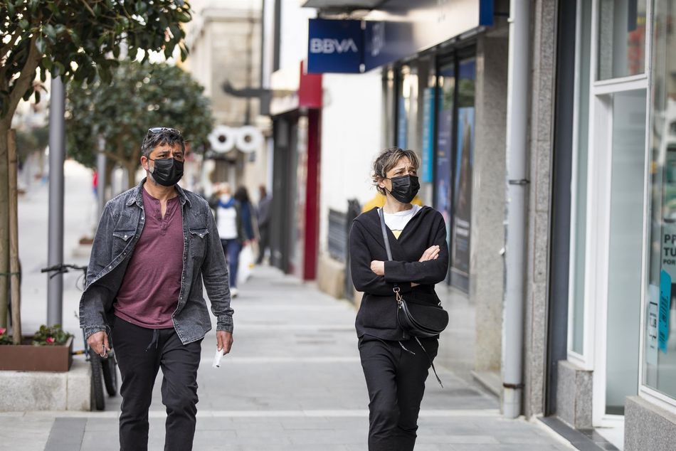 Dos personas por la calle con mascarilla en una imagen de archivo