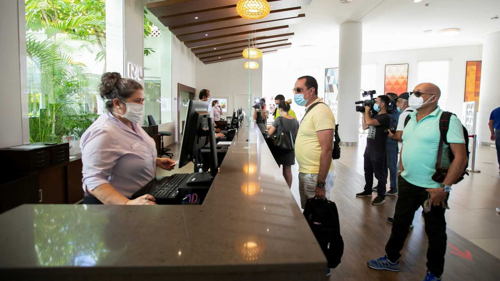 Gente con mascarilla en el interior de un establecimiento hotelero. Foto: EP