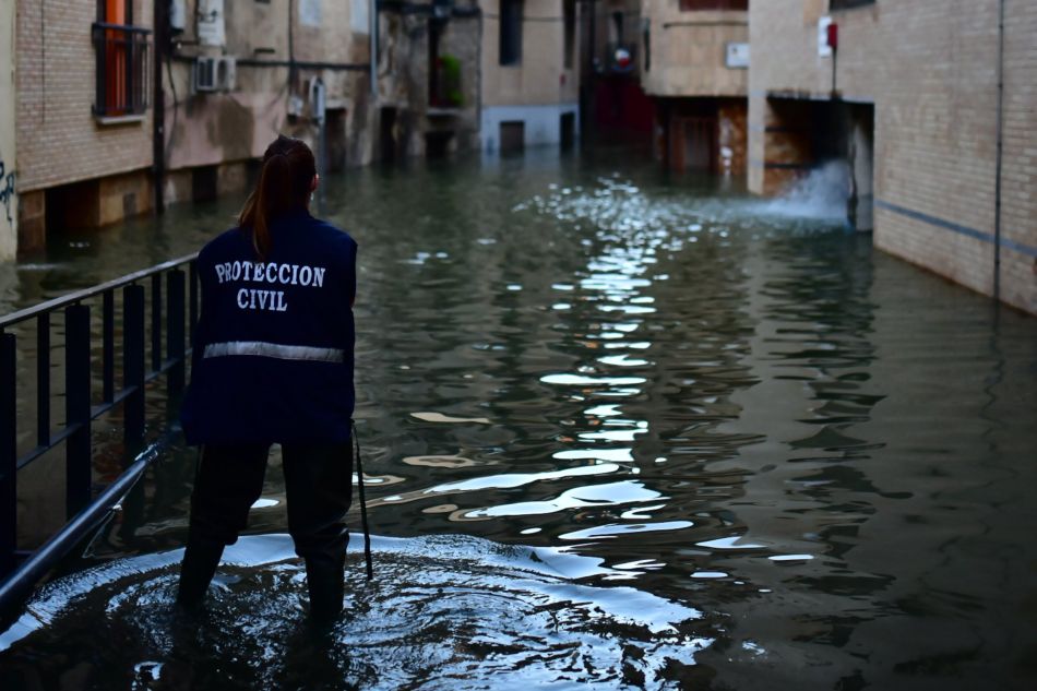 Una trabajadora de Protección Civil en una calle inundada por la crecida del Ebro en Navarra - Iván Delgado - Europa Press