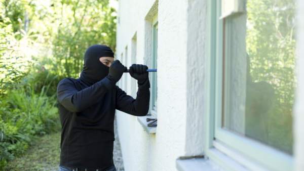 Un ladrón entrando a una casa