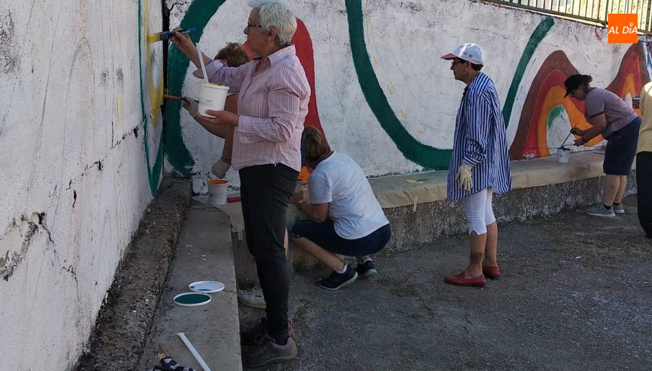 Un grupo de mujeres de la Asociación de féminas de la localidad prepara el muro donde se inscribirán los apodos y motes del municipio