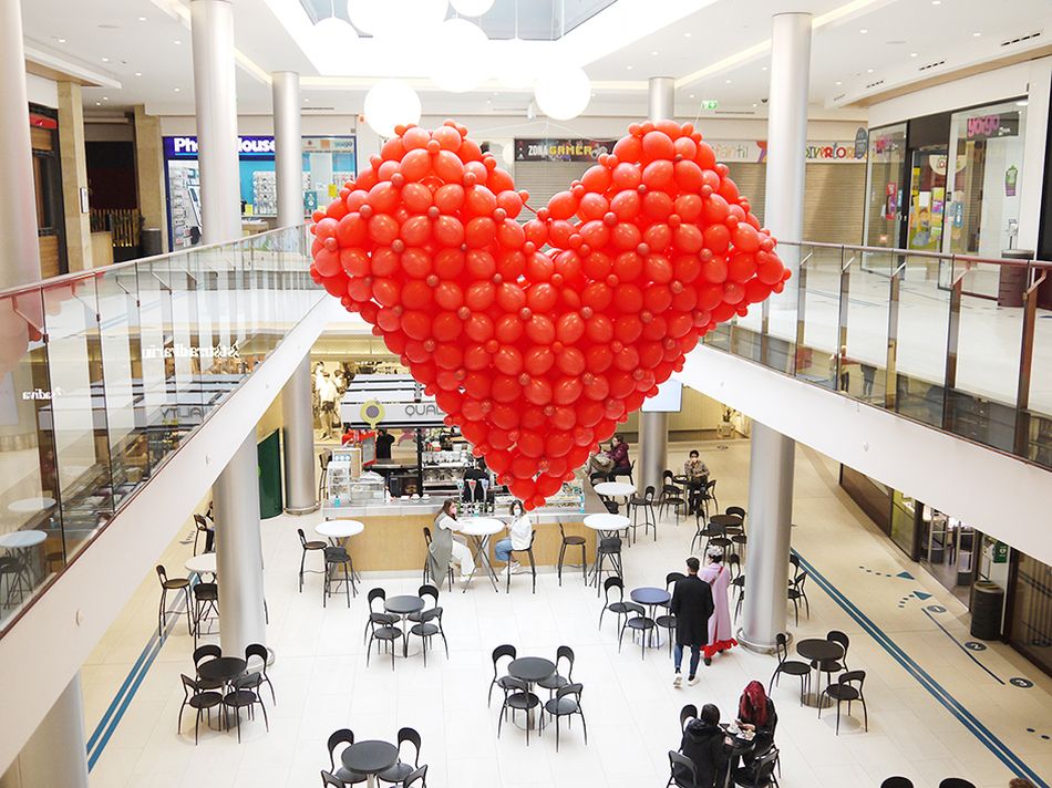 Un gran corazón de globos rojos en la plaza central del Centro Comercial El Tormes