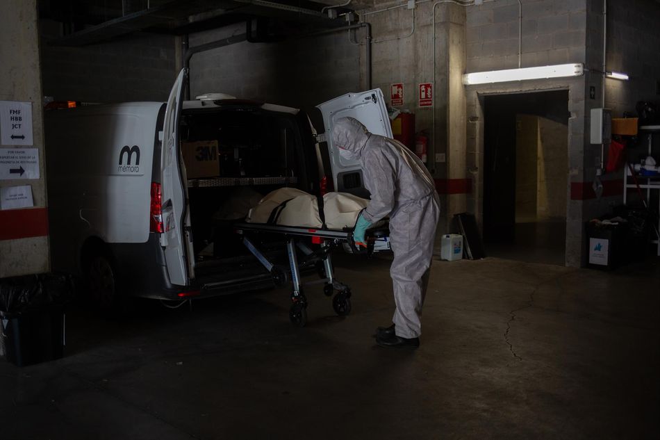 Varios operarios protegidos de los Servicios Funerarios Memora trasladan un cuerpo de una residencia en la primera ola de la pandemia. Foto: EP