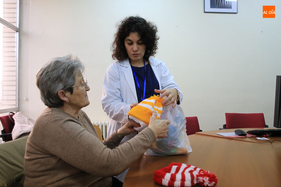 Yasmina Berdei, coordinadora de la Escuela de Esclerosis Múltiple, junto a una paciente del taller en el que tejen los gorros solidarios. Fotos: Alberto Martín