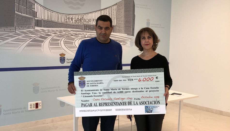 Jesús Garrote, director de la Casa Escuela Santiago Uno, recibe el cheque de manos de la concejala Andrea García