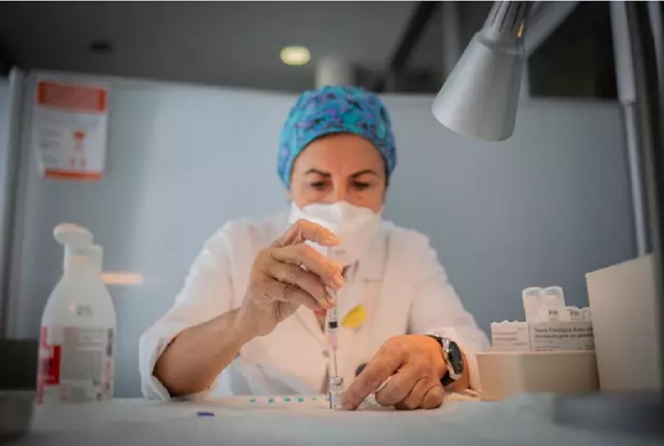 Una enfermera prepara la vacuna Pfizer-BioNtech contra el COVID-19 antes de administrársela a un profesional sanitario | EP