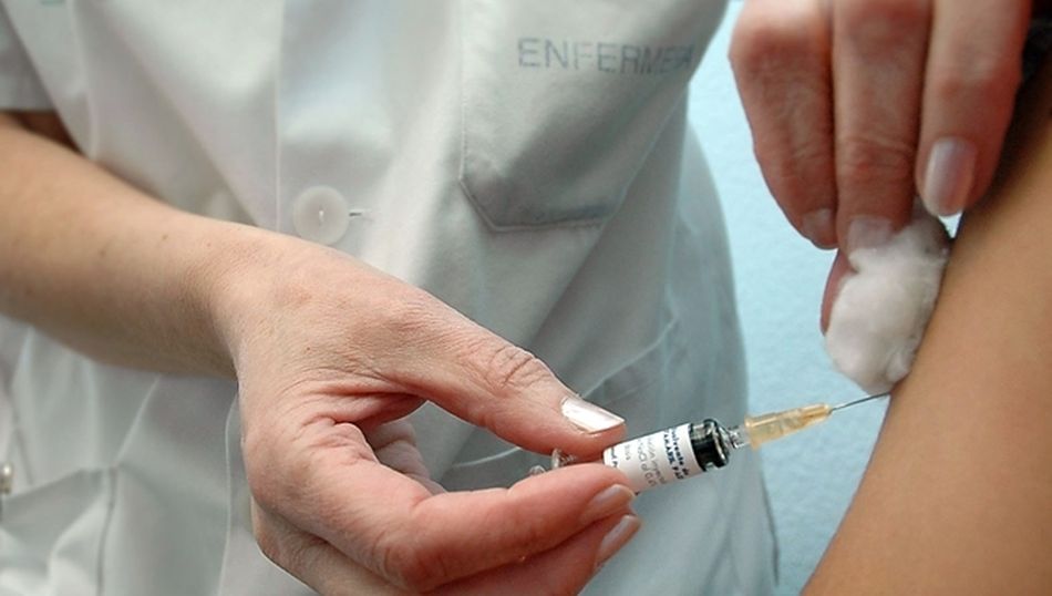 Una enfermera poniendo una vacuna en una imagen de archivo