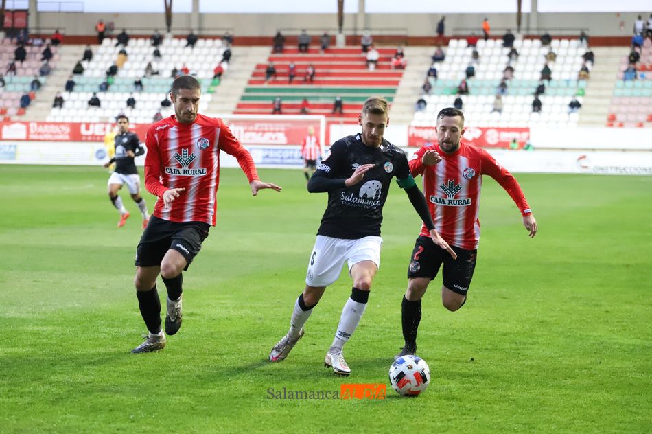 Sergio Molina controla un balón ante la oposición de dos rivales