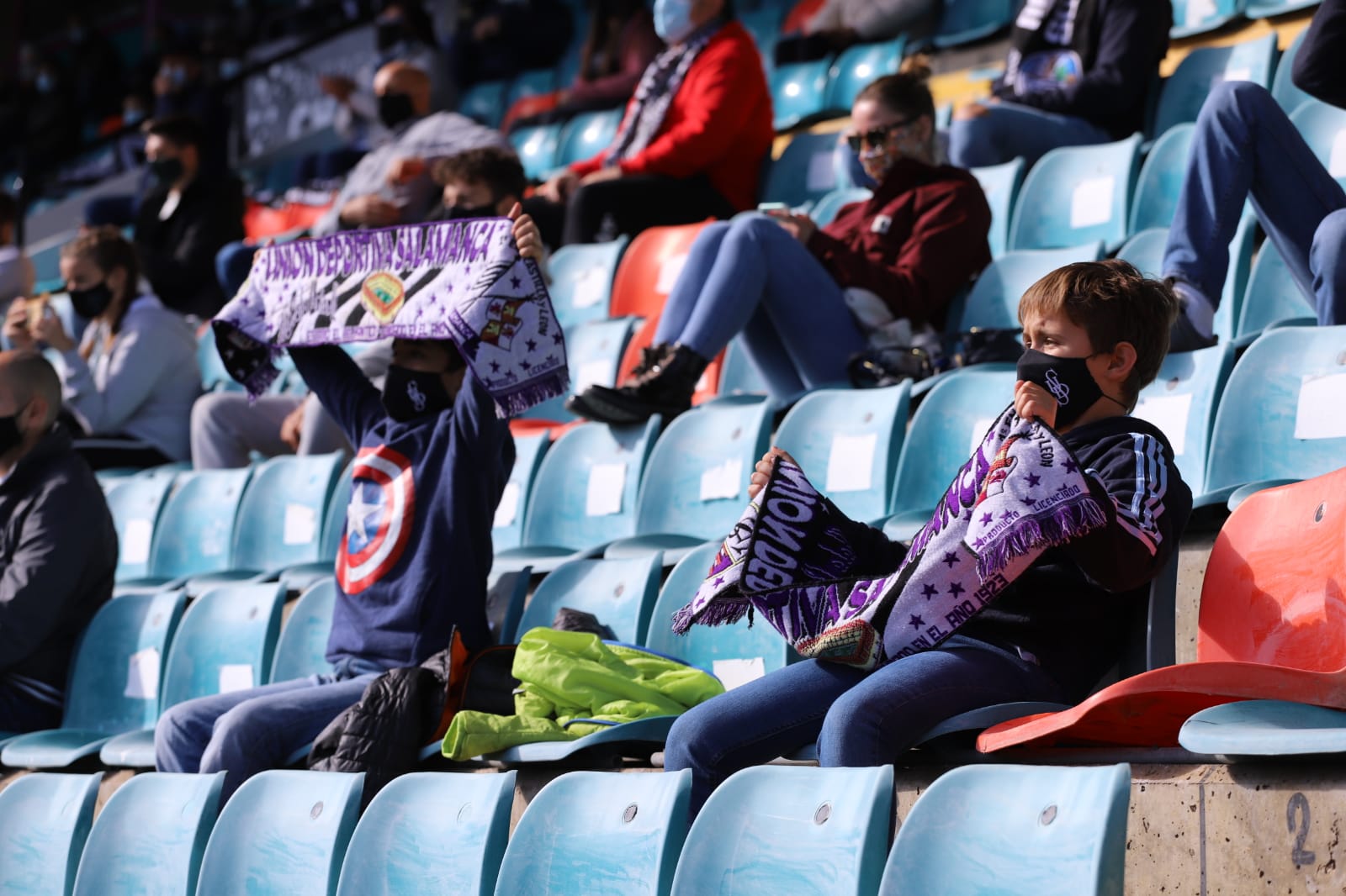 Dos niños, con sus bufandas al viento, en el estadio / Lydia González