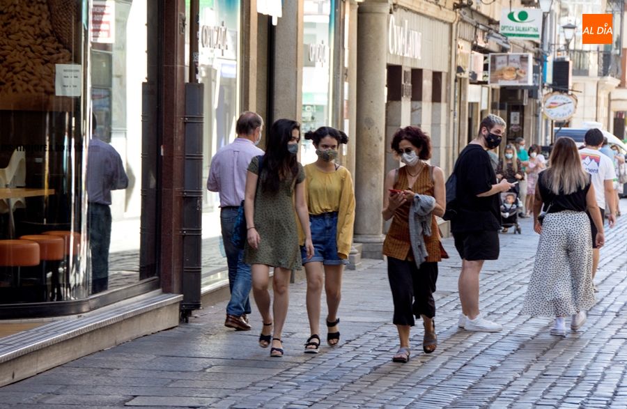 Varias personas pasean por la calle en Salamanca con mascarilla