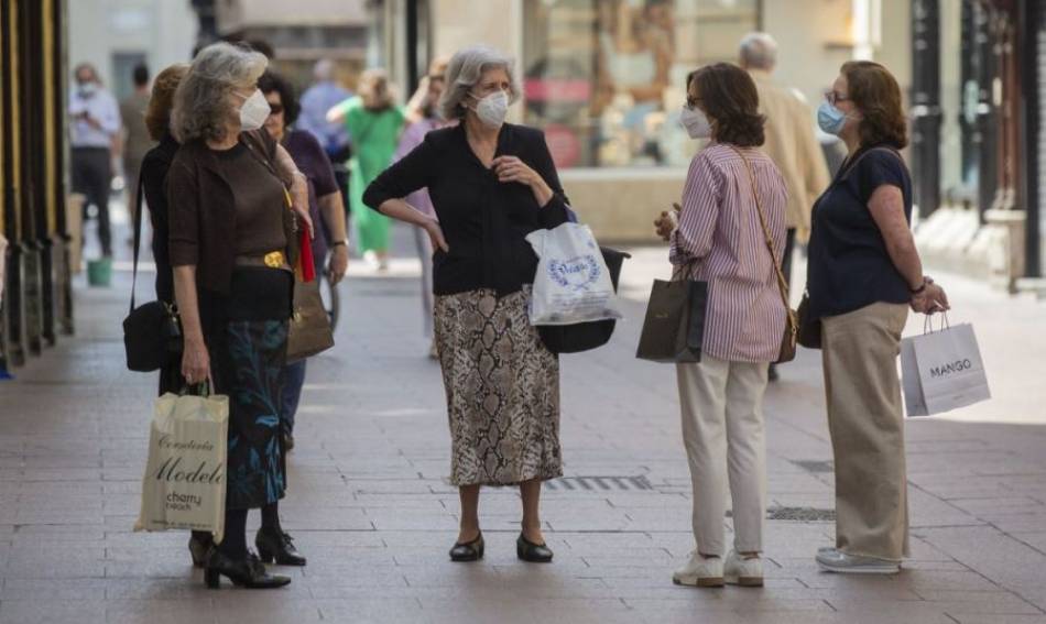 Un grupo de mujeres con mascarillas conversan en la calle