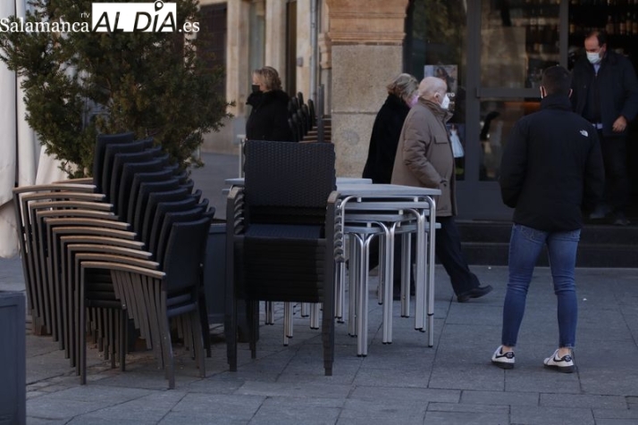 Foto de sillas y mesas recogidas de una terraza de un local de hostelería