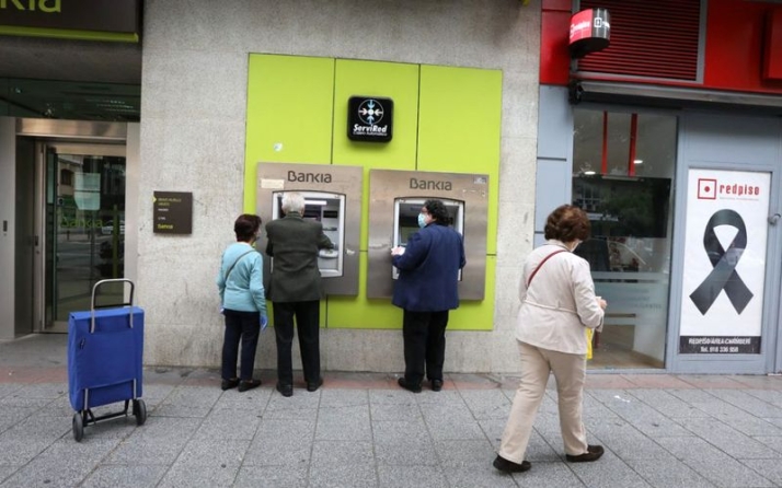 Personas mayores sacan dinero en un cajero de Bankia en Madrid. Foto EP